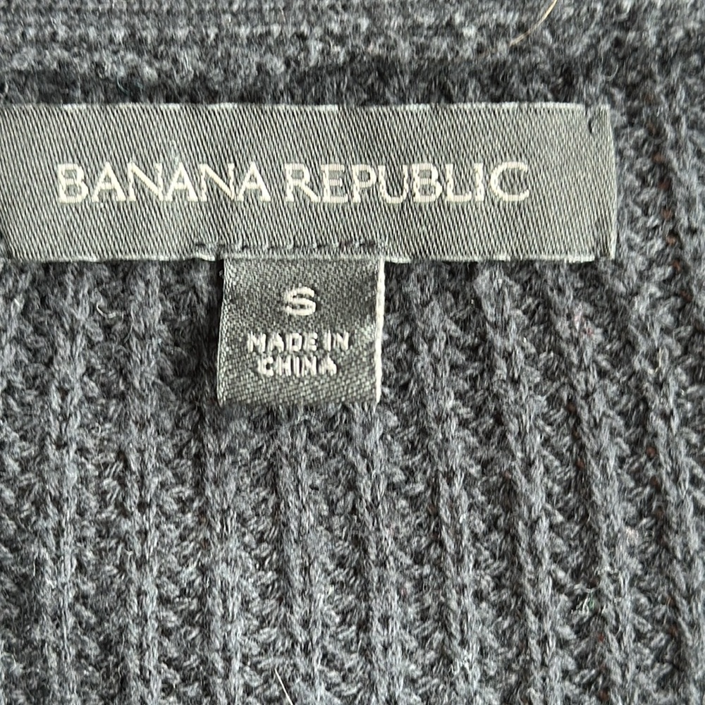 Long “varsity” cardigan, dark navy or black (hard to tell).